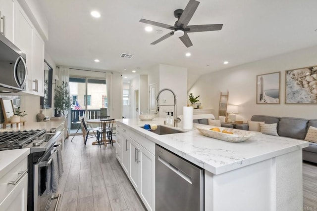 1201 Via Lucero, Oceanside, CA 92056 - kitchen with appliances with stainless steel finishes, open floor plan, ceiling fan, white cabinetry, and light wood-style floors