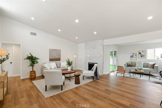 6118 Wolfe St, Lakewood, CA 90713 - living room with light wood-type flooring, vaulted ceiling, recessed lighting, and a fireplace