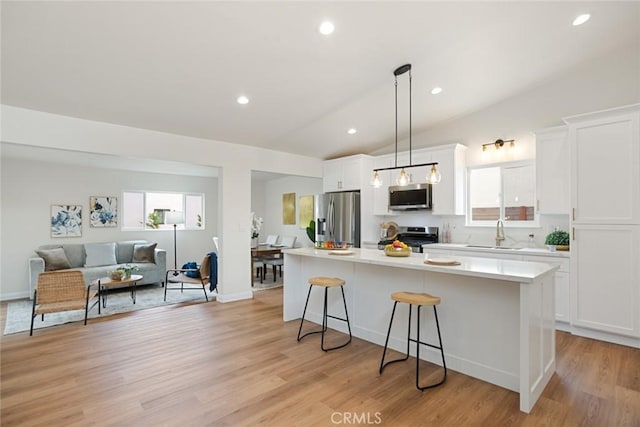 6118 Wolfe St, Lakewood, CA 90713 - kitchen featuring stainless steel appliances, a kitchen breakfast bar, white cabinets, a kitchen island, and light countertops