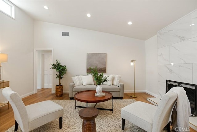 6118 Wolfe St, Lakewood, CA 90713 - living room featuring light wood-style flooring, recessed lighting, a fireplace, and lofted ceiling