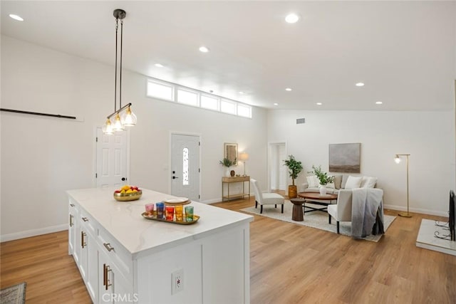 6118 Wolfe St, Lakewood, CA 90713 - kitchen featuring white cabinets, light wood-style flooring, recessed lighting, a center island, and hanging light fixtures
