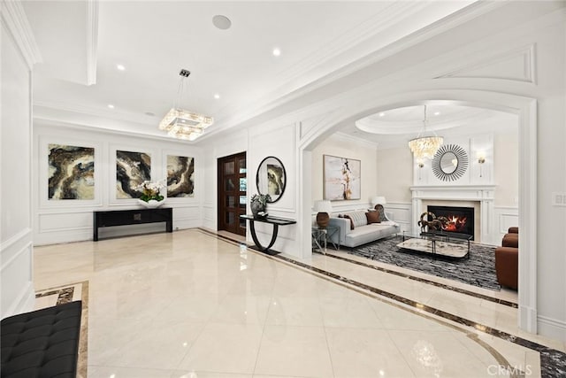 300 W Las Flores Ave, Arcadia, CA 91007 - living room with a decorative wall, ornamental molding, a chandelier, a raised ceiling, and a warm lit fireplace