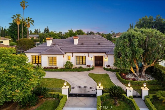 300 W Las Flores Ave, Arcadia, CA 91007 - french country style house featuring a gate, a tiled roof, a chimney, stucco siding, and a fenced front yard