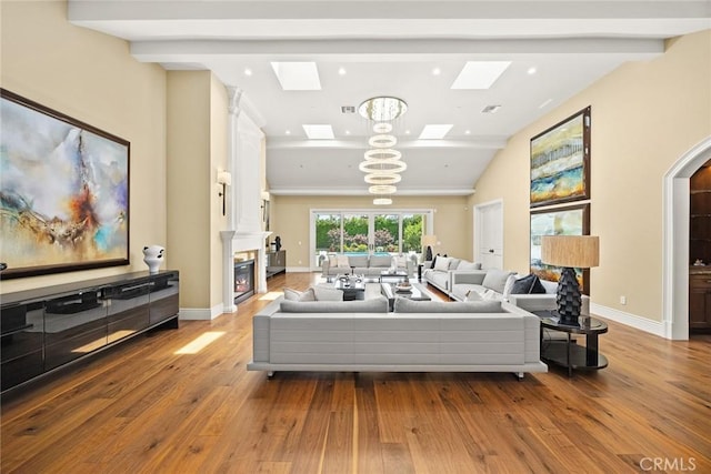 300 W Las Flores Ave, Arcadia, CA 91007 - living room with a skylight, hardwood / wood-style floors, arched walkways, lofted ceiling, and a glass covered fireplace