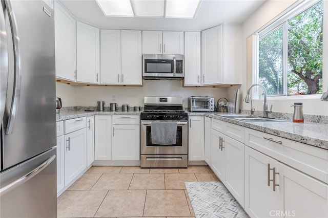 38342 5th Pl W, Palmdale, CA 93551 - kitchen with stainless steel appliances, white cabinets, light stone countertops, and light tile patterned flooring