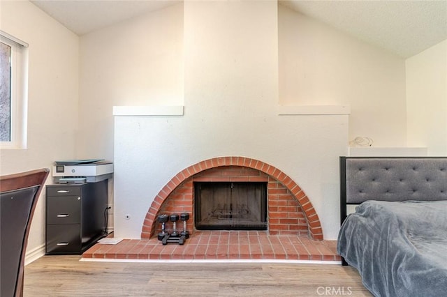 38342 5th Pl W, Palmdale, CA 93551 - bedroom featuring wood finished floors, a brick fireplace, and lofted ceiling