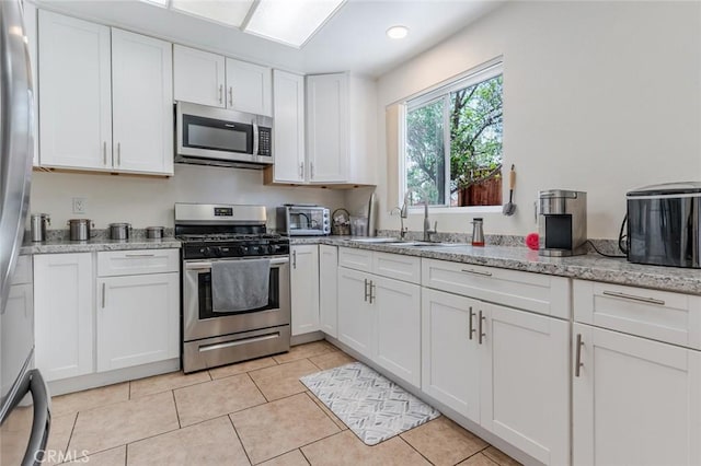38342 5th Pl W, Palmdale, CA 93551 - kitchen featuring stainless steel appliances, white cabinets, light stone counters, light tile patterned floors, and recessed lighting