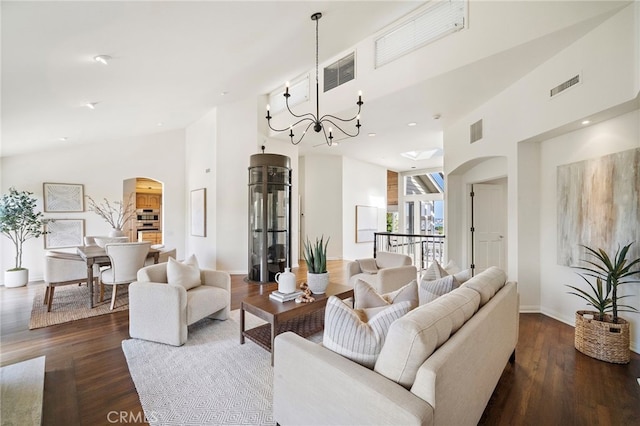 520 Kings Rd, Newport Beach, CA 92663 - living room featuring arched walkways, a towering ceiling, a chandelier, dark wood-style floors, and recessed lighting