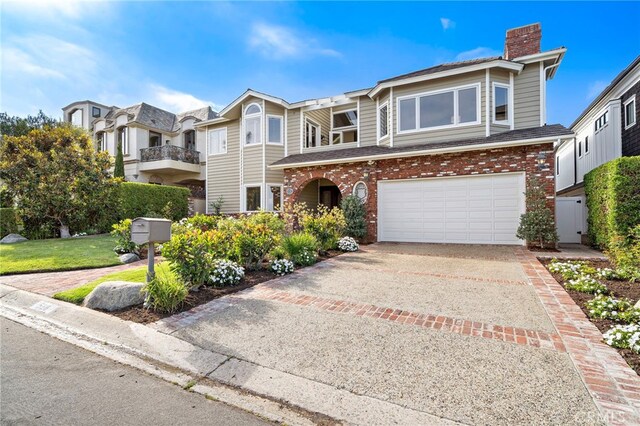 520 Kings Rd, Newport Beach, CA 92663 - view of front facade with a chimney, a garage, driveway, and brick siding