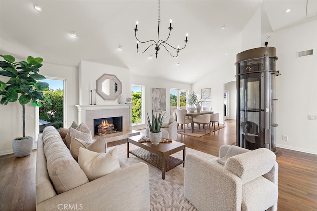 520 Kings Rd, Newport Beach, CA 92663 - living area featuring vaulted ceiling, wood finished floors, a chandelier, recessed lighting, and a warm lit fireplace