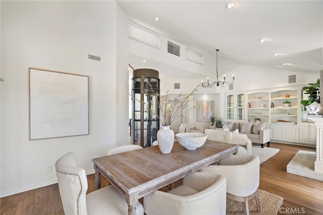 520 Kings Rd, Newport Beach, CA 92663 - dining space featuring a chandelier, high vaulted ceiling, and wood finished floors
