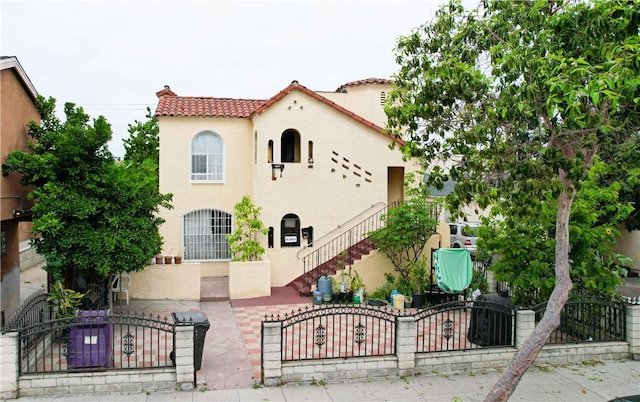 1451 Walnut Ave, Long Beach, CA 90813 - mediterranean / spanish home with stucco siding, a fenced front yard, stairs, and a tile roof