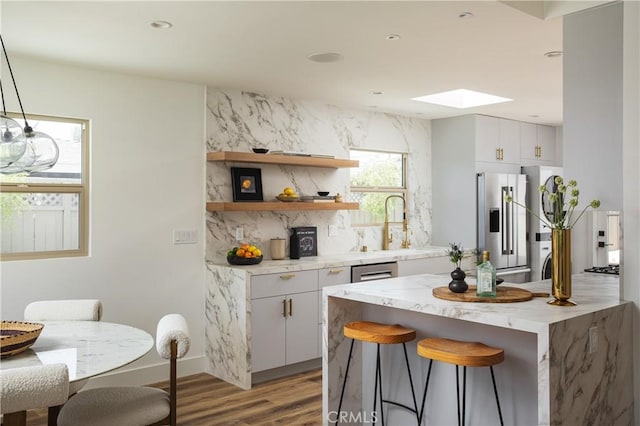 212 E 19th St, Costa Mesa, CA 92627 - kitchen featuring stainless steel fridge with ice dispenser, light wood-style floors, a skylight, a breakfast bar area, and open shelves