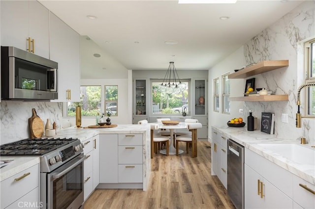 212 E 19th St, Costa Mesa, CA 92627 - kitchen with appliances with stainless steel finishes, light wood finished floors, light stone counters, backsplash, and white cabinets