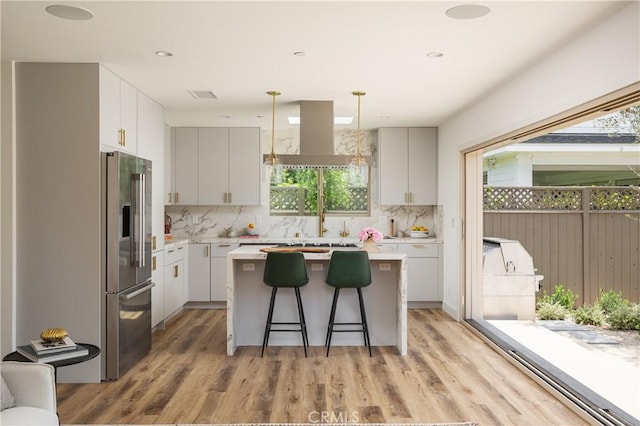 212 E 19th St, Costa Mesa, CA 92627 - kitchen with high end refrigerator, plenty of natural light, a kitchen island, and light countertops