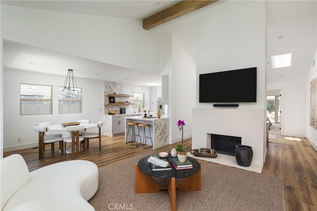 212 E 19th St, Costa Mesa, CA 92627 - living room featuring wood finished floors, a fireplace with flush hearth, high vaulted ceiling, and beamed ceiling