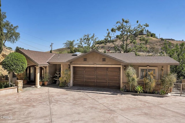 9999 Wornom Ave, Sunland, CA 91040 - ranch-style house featuring stucco siding, a garage, and concrete driveway