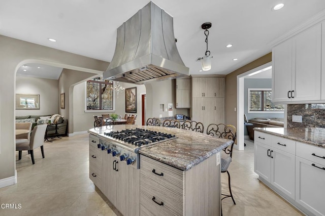 9999 Wornom Ave, Sunland, CA 91040 - kitchen with island exhaust hood, stainless steel gas stovetop, recessed lighting, a center island, and light stone countertops