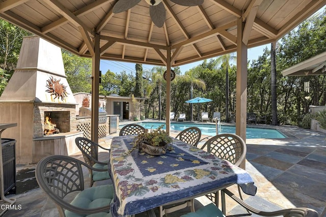 9999 Wornom Ave, Sunland, CA 91040 - view of patio featuring an outdoor stone fireplace, a gazebo, a ceiling fan, and outdoor dining space