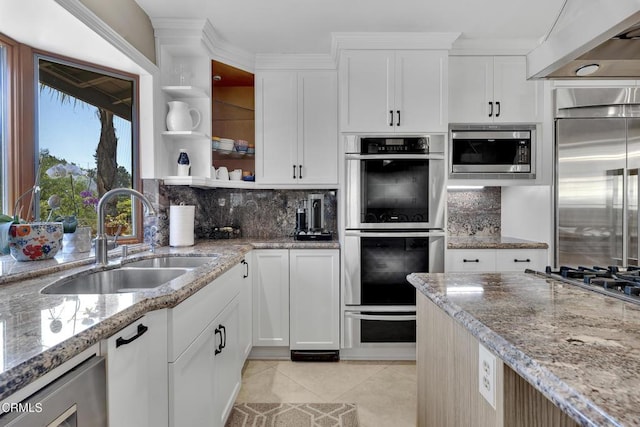 9999 Wornom Ave, Sunland, CA 91040 - kitchen featuring built in appliances, open shelves, decorative backsplash, light tile patterned floors, and light stone countertops