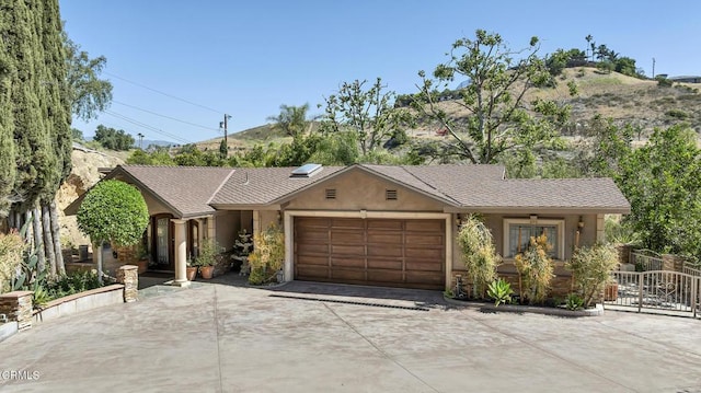 9999 Wornom Ave, Sunland, CA 91040 - single story home with concrete driveway, an attached garage, stucco siding, and a mountain view