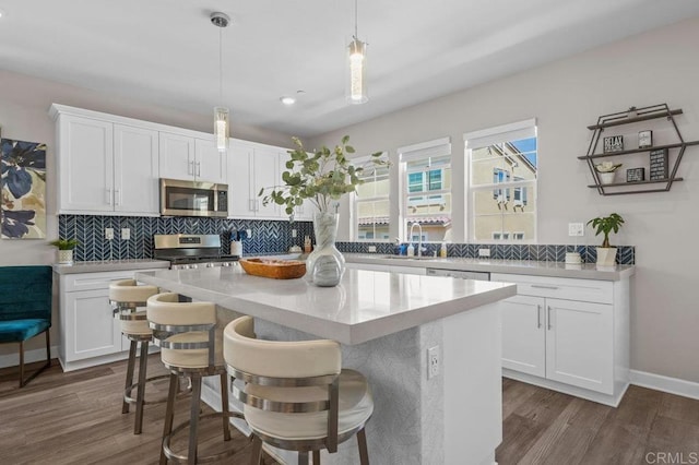 11015 Peyton Way, San Diego, CA 92129 - kitchen with stainless steel appliances, decorative backsplash, white cabinetry, dark wood finished floors, and recessed lighting