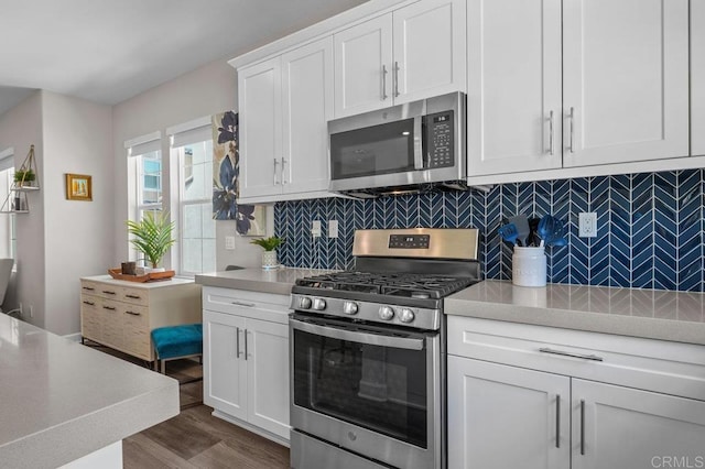 11015 Peyton Way, San Diego, CA 92129 - kitchen featuring stainless steel appliances, light countertops, white cabinets, dark wood finished floors, and tasteful backsplash