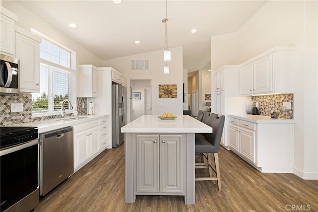 635 Boquest Blvd, Paradise, CA 95969 - kitchen featuring stainless steel appliances, a center island, vaulted ceiling, white cabinets, and a breakfast bar