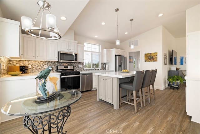 635 Boquest Blvd, Paradise, CA 95969 - kitchen with stainless steel appliances, wood finished floors, light countertops, a center island, and tasteful backsplash