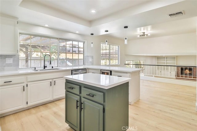 20591 Celtic St, Chatsworth, CA 91311 - kitchen featuring a center island, a tray ceiling, light wood-type flooring, decorative backsplash, and recessed lighting