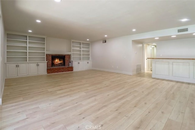 20591 Celtic St, Chatsworth, CA 91311 - unfurnished living room with recessed lighting, light wood-type flooring, a brick fireplace, and built in shelves