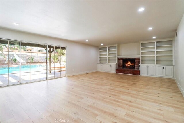 20591 Celtic St, Chatsworth, CA 91311 - unfurnished living room with recessed lighting, light wood finished floors, a brick fireplace, and built in shelves