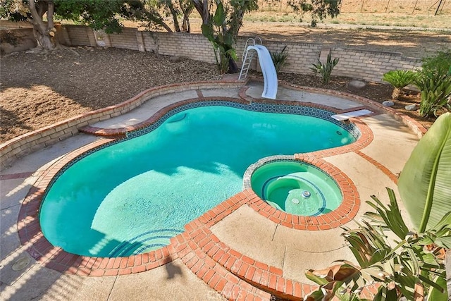 20591 Celtic St, Chatsworth, CA 91311 - view of swimming pool featuring a water slide, a pool with connected hot tub, and a fenced backyard
