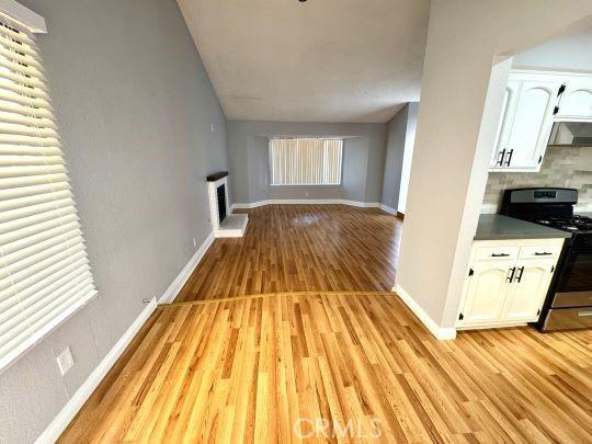 2748 Delmar Ave, Mojave, CA 93501 - unfurnished living room featuring light wood-type flooring and a fireplace