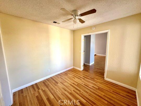 2748 Delmar Ave, Mojave, CA 93501 - empty room featuring wood finished floors, ceiling fan, and a textured ceiling