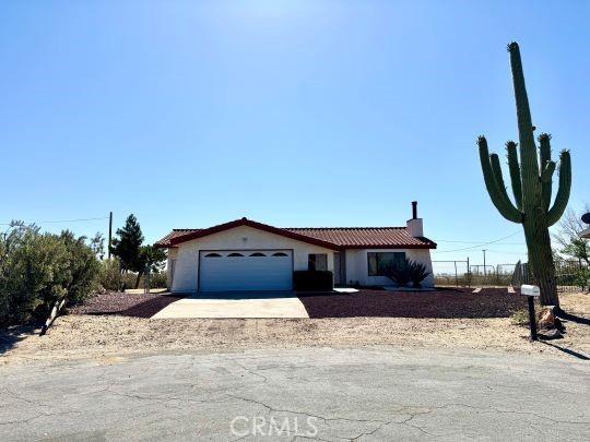 2748 Delmar Ave, Mojave, CA 93501 - view of front of property with a garage, driveway, a chimney, and stucco siding
