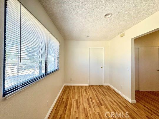 2748 Delmar Ave, Mojave, CA 93501 - unfurnished room with a textured ceiling and light wood-style floors