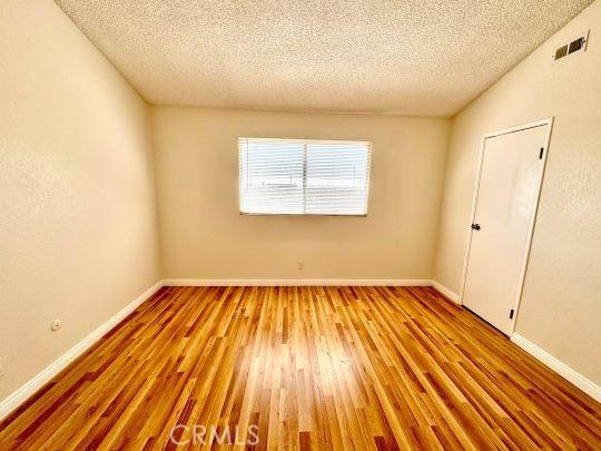 2748 Delmar Ave, Mojave, CA 93501 - unfurnished room with a textured ceiling and wood finished floors