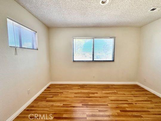 2748 Delmar Ave, Mojave, CA 93501 - spare room featuring wood finished floors and a textured ceiling
