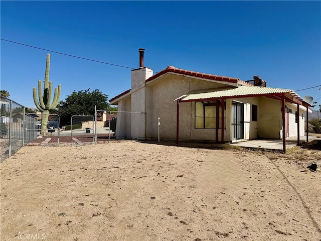 2748 Delmar Ave, Mojave, CA 93501 - rear view of property with a chimney, stucco siding, a patio area, and a gate