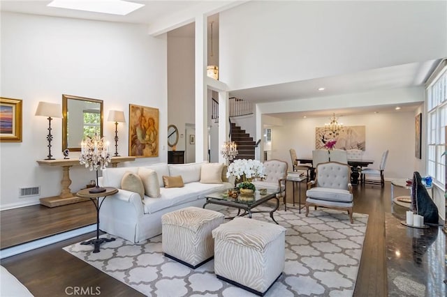 10411 Windtree Dr, Los Angeles, CA 90077 - living room with a chandelier, stairway, a towering ceiling, wood finished floors, and a skylight