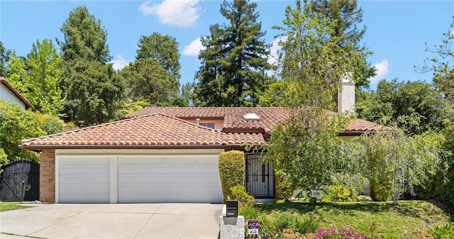 10411 Windtree Dr, Los Angeles, CA 90077 - mediterranean / spanish-style home featuring a tiled roof, concrete driveway, an attached garage, a chimney, and a gate