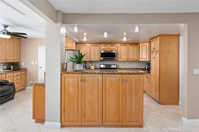 4360 E Addington Dr, Anaheim, CA 92807 - kitchen with stainless steel appliances, dark stone counters, light tile patterned flooring, ceiling fan, and recessed lighting