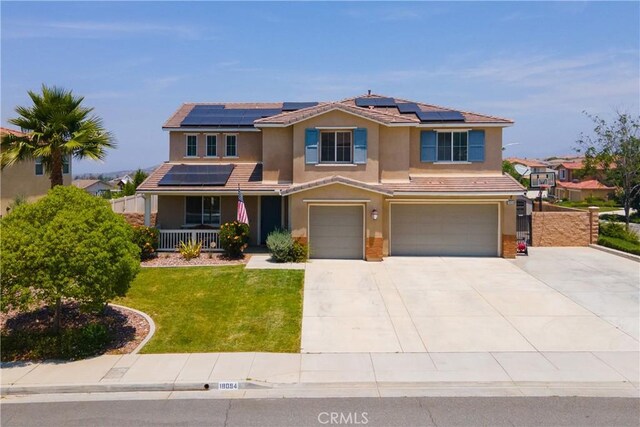 18094 Olivenhain Dr, Riverside, CA 92508 - view of front of house with stucco siding, covered porch, an attached garage, and solar panels