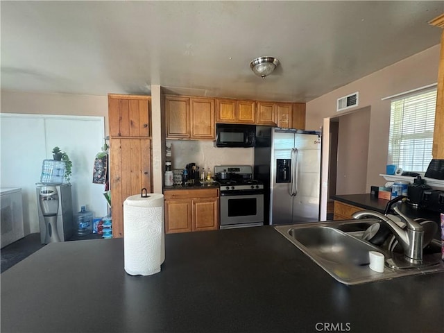 401 S R St, Lompoc, CA 93436 - kitchen with stainless steel appliances, dark countertops, and brown cabinets