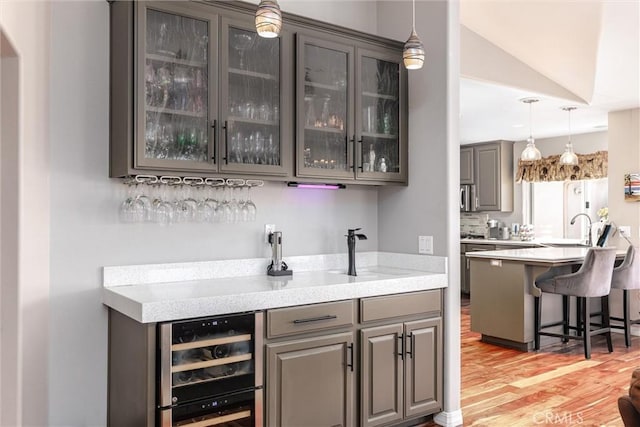 620 Camino Roble, Nipomo, CA 93444 - indoor wet bar with wine cooler, light wood-style floors, hanging light fixtures, and lofted ceiling