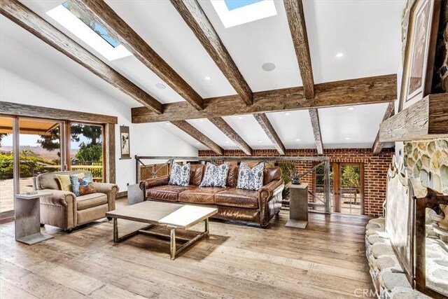 27151 Mission Hills Dr, San Juan Capistrano, CA 92675 - living room featuring a skylight, hardwood / wood-style floors, a fireplace with raised hearth, and french doors