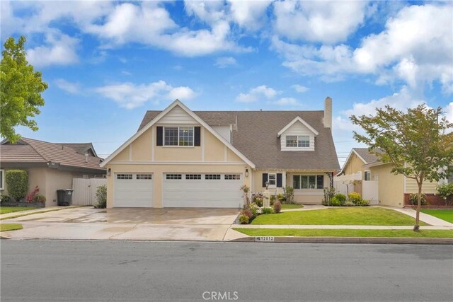 12012 Paseo Bonita, Los Alamitos, CA 90720 - view of front of house with driveway, a chimney, stucco siding, and roof with shingles
