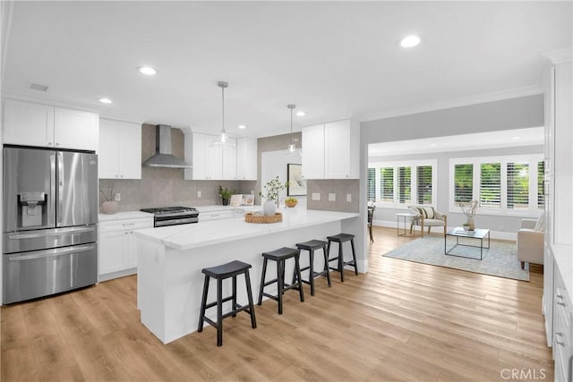 12012 Paseo Bonita, Los Alamitos, CA 90720 - kitchen with stainless steel appliances, wall chimney exhaust hood, light countertops, a breakfast bar area, and recessed lighting