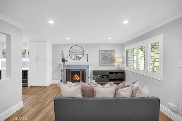 12012 Paseo Bonita, Los Alamitos, CA 90720 - living room with wine cooler, ornamental molding, recessed lighting, light wood finished floors, and a premium fireplace